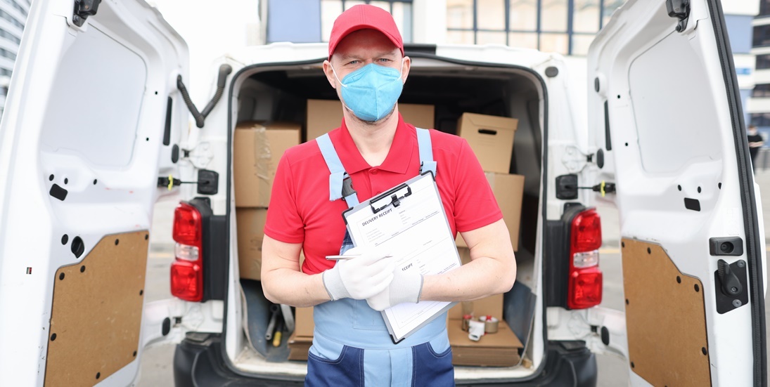 homem com máscara médica realizando entrega de encomendas